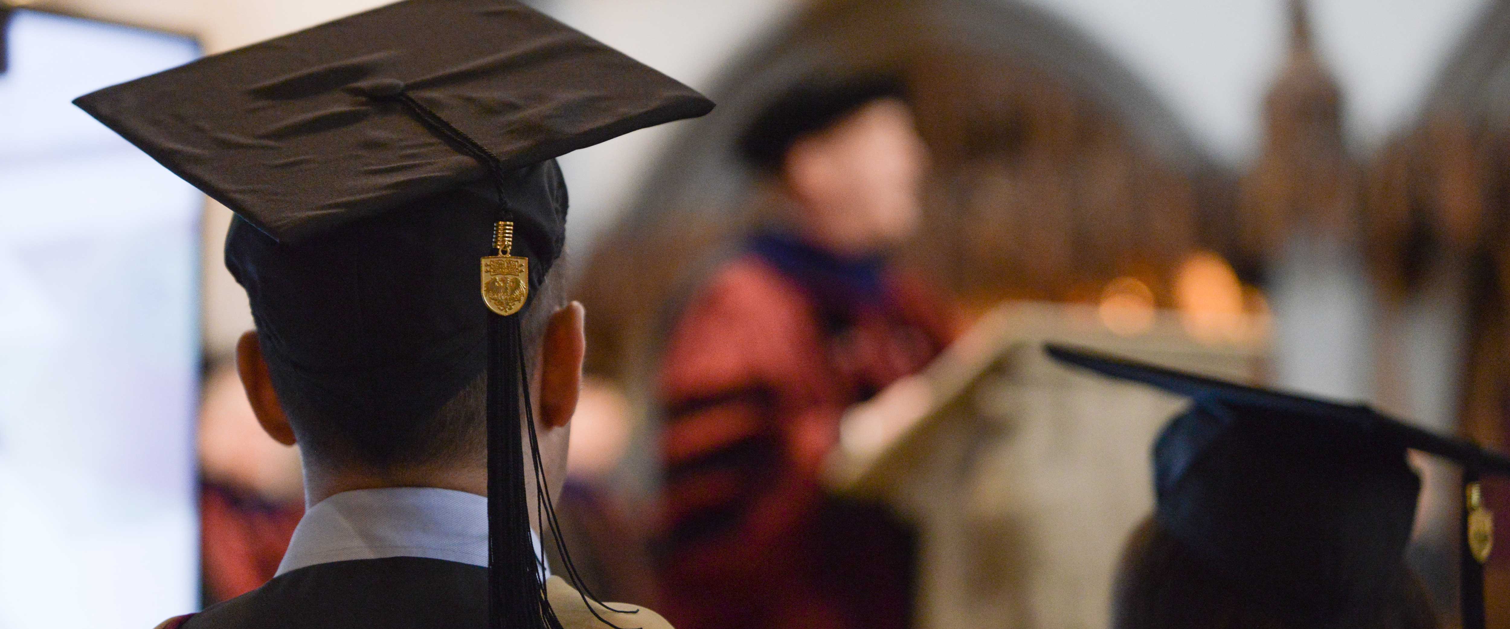 Chicago Booth graduating student listening to a commencement speaker in Rockefeller Chapel