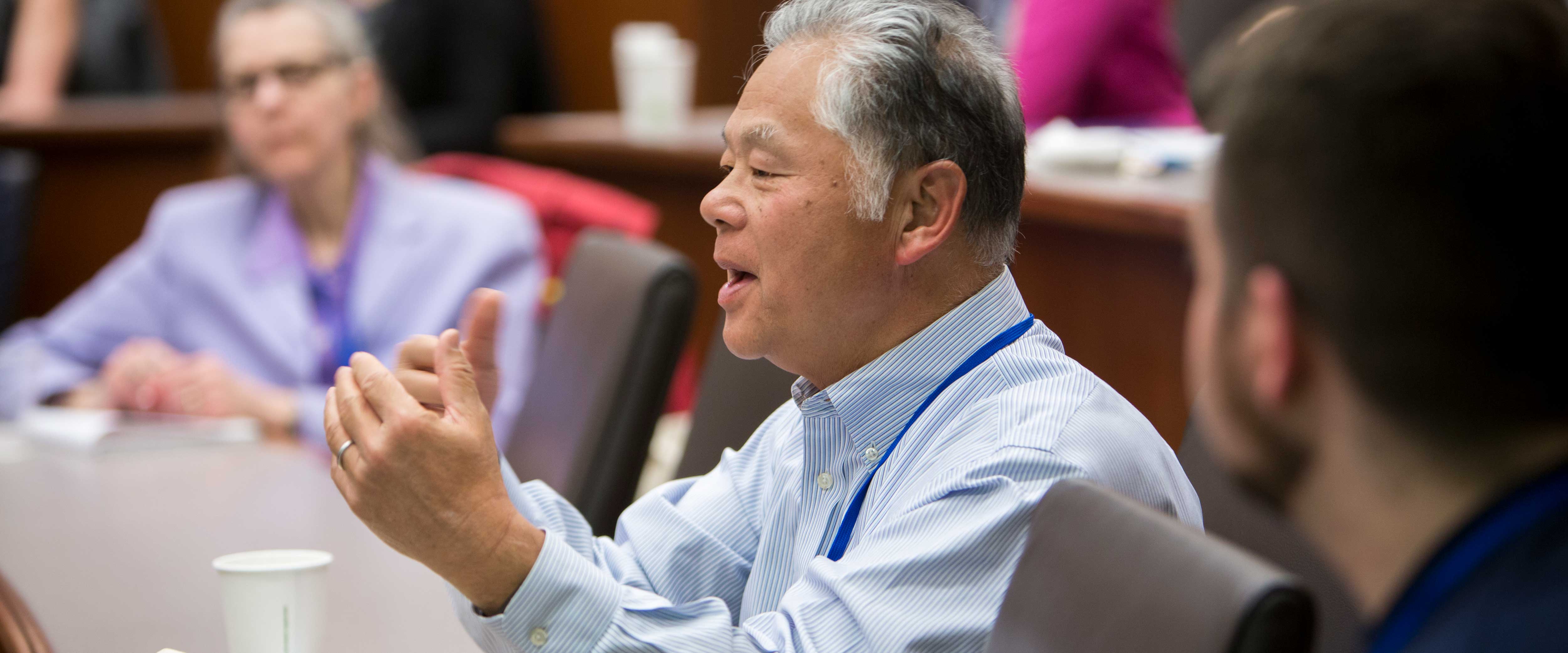 Man in a Chicago Booth classroom answering a question